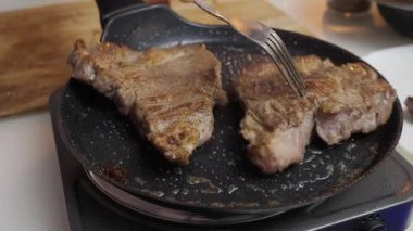 Lezzetli ve lezzetli biftekler sıcacık bir tavada çok güzel kızarıyor, sağlıklı bir yemek için mükemmel.