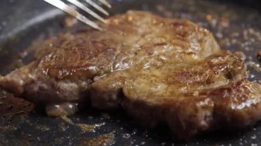 Çok güzel pişirilmiş domuz pirzolası kızartma tavasında cızırdıyor, inanılmaz sulu dokusunu ve aromasını sergiliyor
