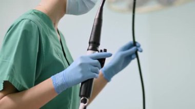 Önlük giymiş kendini adamış bir sağlık çalışanı cerrahi ortamda gerekli tıbbi ekipmanları hazırlıyor.