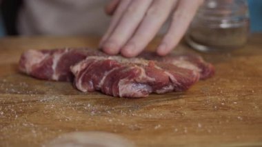 Tahta bir tahtanın üzerine taze kesilmiş biftek. Lezzetli bir baharat için hazır ve bekliyor. Yüksek kalite 4k görüntü