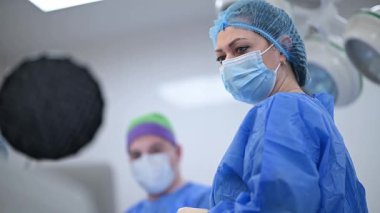 Cerrahlar şimdi önlüklerini giyip titizlikle modern ve gelişmiş bir ameliyathanede ameliyata hazırlanıyorlar.