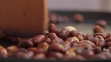 Kahve çekirdekleri kavrulurken, zengin dokularını ve canlı renk özelliklerini gösteren detaylı ve yakından çekilmiş bir fotoğraf.