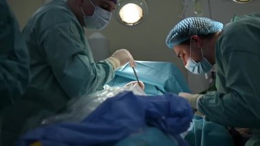 Yakın çekim, titizlikle steril bir ortamda çok önemli bir cerrahi işlem yapan kendini adamış cerrahları gösteriyor.