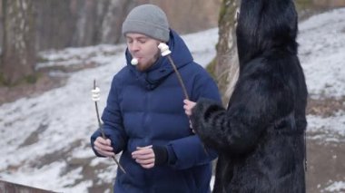 Karlı bir arazide şekerleme kızartan bir çift, kış bağının özünü gözler önüne seriyor.