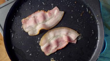 Lezzetli pastırma kızartma tavasında neşeyle cızırdıyor, havayı dolduran ağız sulandıran bir koku yaratıyor.