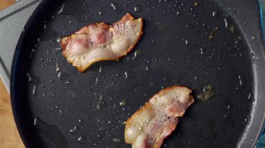 Tavada kızaran lezzetli domuz pastırması şeritleri ağız sulandırıcı dokuları ve zengin tatları ön plana çıkarıyor.