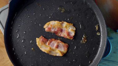 Aromatik ve lezzetli pastırma cızırdıyor ve tavada pişiriyor, çıtır çıtır dokular ve heyecan verici tatlar sergiliyor.