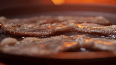 Ağız sulandıran ve lezzetli pastırma dilimleri sıcaktan pişmiş tavada çok güzel cızırdıyor ve kahverengileşiyor.
