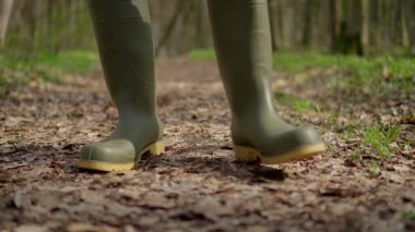 Rengarenk yapraklarla çevrili yeşil çizmelerle huzurlu bir orman yolunda yürürken doğanın tadını çıkarıyorum.