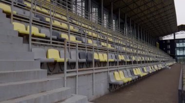 Modern stadyum oturma yerlerinin geniş bir görünümü, çağdaş tasarım estetiğini sergiliyor.