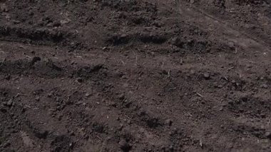Yeni sürülmüş toprağın detaylı görüntüsü çeşitli dokuları ve tarım ekipmanlarının karmaşık desenlerini gösteriyor.