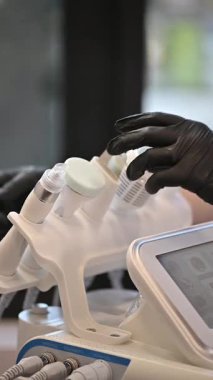 Yetenekli bir dermatoloğun lüks estetik ortamında yüz bakımı için modern aletler kullandığını gösteriyor.