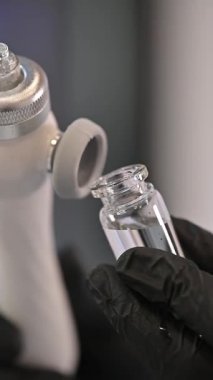 Tıbbi uygulamalar için tasarlanmış bir enjektöre dikkatlice ve kesin olarak bağlı olan bir şişenin yakın görüntüsü