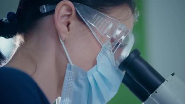 Özel bir klinik laboratuvarında, yetenekli bir laboratuvar teknisyeni mikroskop kullanarak çeşitli örnekleri dikkatle inceliyor.