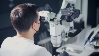 Yetenekli bir tıp uzmanı detaylı göz muayeneleri ve karmaşık ameliyatlar için yüksek teknolojili mikroskop kullanır.