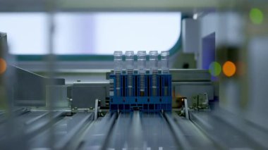 Otomatik laboratuvar şişelerinin hassas mekanizmalarda sorunsuzca hareket ettiğini gösteren dinamik bir sahne
