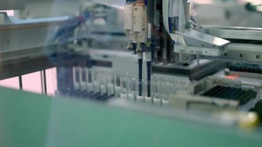 Otomatik laboratuvar ekipmanları modern bir bilimsel tesiste örnek işleme görevlerini etkili bir şekilde yürütüyor.