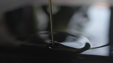 Zeytinyağının güzelce detaylandırılmış bir yakın çekimi, özenle pürüzsüz ve parlak dokusunu vurguluyor.