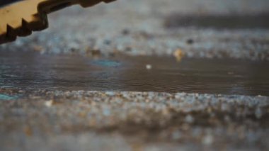 Yağmur suyunun su birikintilerinde lastik botlarla sıçrayan görüntüsü yağmurlu bir günün neşeli havasını güzel bir şekilde yakalıyor.