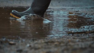 Su birikintilerindeki sıçramaların yakın çekimleri büyüleyici yağmurlu atmosferi ve çamurlu çevreyi canlı bir şekilde gösteriyor.