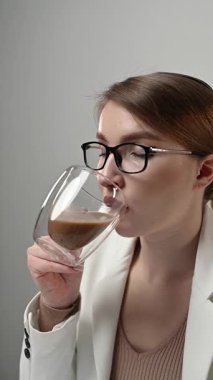 Sıcak kahve fincanı içen hoş esmer kadının yakın çekimde rahat bir evde sabahın tadını çıkarması. Evcil pijamalı, çay fincanlarıyla dinlenen mutlu bir kadın. Yüksek kaliteli FullHD görüntüler