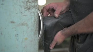 Yakın çekim, ayakkabı için taban kısımlarını yapıştıran bir adamın elleri. Özel el yapımı bir fabrikada ayakkabı üretimi. Yüksek kaliteli FullHD görüntüler