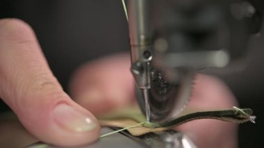 Bir dikiş makinesinin detaylı yakın plan görüntüsü kumaşı ustalıkla dikmek, hem hassasiyeti hem de zanaatı sergilemek.