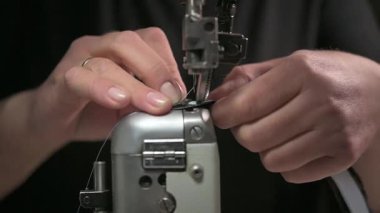 Bir dikiş makinesinin detaylı yakın plan görüntüsü kumaşı ustalıkla dikmek, hem hassasiyeti hem de zanaatı sergilemek.