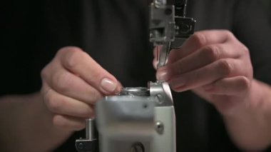 Bir dikiş makinesinin detaylı yakın plan görüntüsü kumaşı ustalıkla dikmek, hem hassasiyeti hem de zanaatı sergilemek.