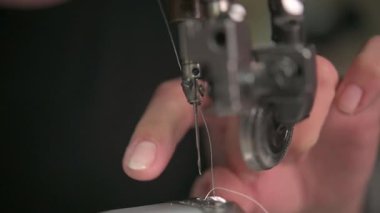 Bir dikiş makinesinin detaylı yakın plan görüntüsü kumaşı ustalıkla dikmek, hem hassasiyeti hem de zanaatı sergilemek.