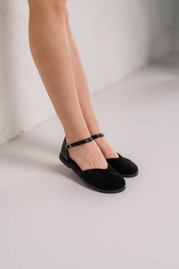 Bir kadın şık bir çift siyah ayakkabı giyer. Bileklerine destek ve rahatlık için kayışlar takılır.