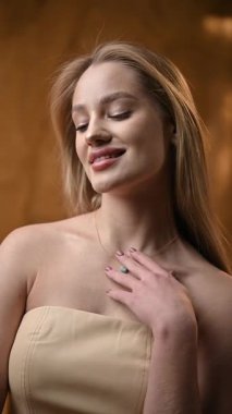 Zarif bir kadın, güzelliğini ve sadeliğini zahmetsizce sergileyerek zarif bir şekilde ışık altında poz verir.