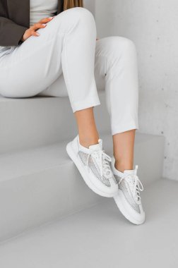 Şık beyaz spor ayakkabılar, özel dikim pantolonlar, gündelik ama cilalı kıyafetler için mükemmel. Sokak tarzı ve günlük kıyafet için ideal..