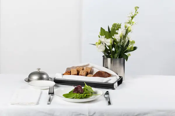 白い背景のパンと花とプレートの花瓶 — ストック写真