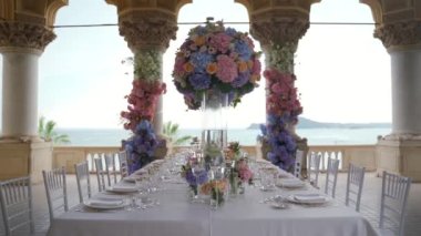 İtalya 'da deniz manzaralı çiçeklerle süslenmiş düğün masası. Yüksek kaliteli FullHD görüntüler