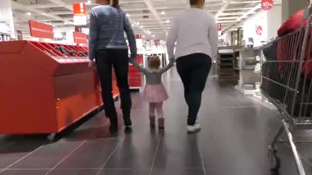 Две Женщины Маленькая Девочка Идут Через Мебельный Магазин — стоковое видео