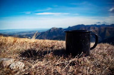 Dağlardaki çimlerin üzerinde mevsimlik siyah kupa
