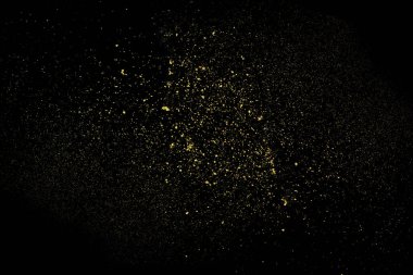 Siyah arka planda altın tozu patlaması. Hareketi dondur.