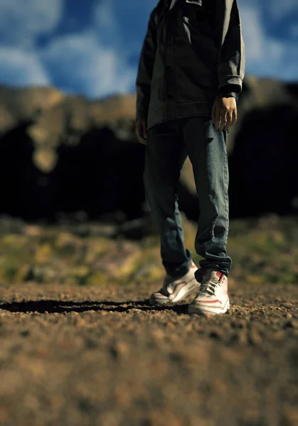 青い曇り空の下で岩の多い風景の中にジーンズやスニーカーの男の子 3Dレンダリング — ストック写真