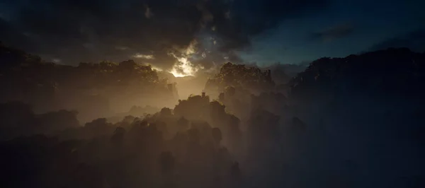 云雾丛林中 有石柱 夕阳西下 天空多云 — 图库照片