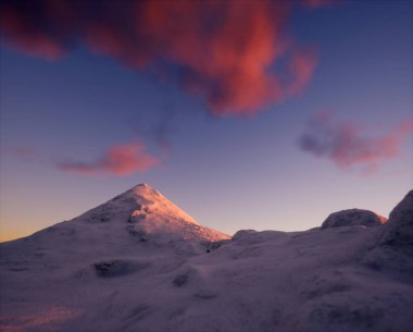 Gün batımında bulutlu bir gökyüzünün altındaki karlı dağ.