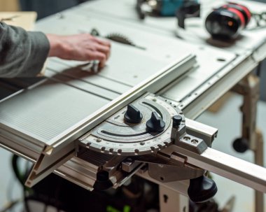 Testereli, testereli, testereli, testereli ve koruyucu kulaklı bir adam..