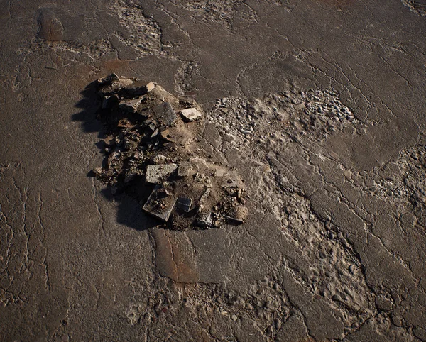古い割れたタールマックの表面に瓦礫の山 — ストック写真