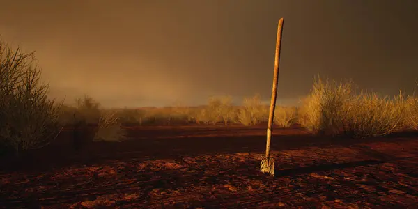 Spade in ground in desolate desert during sunset.
