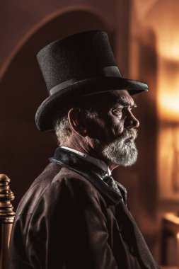 Geceleri odada şapka ve palto giyen Viktorya dönemi tarzı son sınıf öğrencisi..