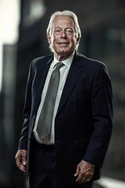 Şehirde kravatlı, mavi takım elbiseli, gülümseyen bir işadamı..