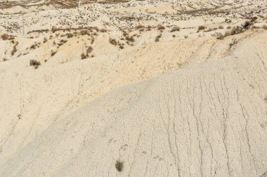 Güneşli bir günde kurak bir arazide dağ oluşumları.