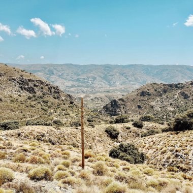 Pampaneira 'nın dağlık manzarasında elektrik kabloları olan tahta bir direk. Granada, Endülüs, İspanya.