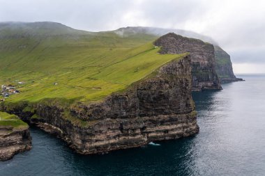 Faroe Adaları 'nın yukarıdan ele geçirilen büyüleyici uçurumlarını keşfedin. Bu insansız hava aracı görüntüsü manzaranın ve kıyı şeridinin doğal güzelliğini vurgular..