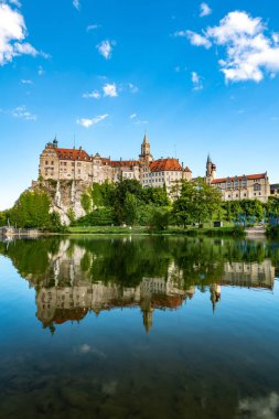 Schloss Sigmaringen 'in sakin suları yansıtan çarpıcı yaz sahnesi. Seyahat ve mimarlık meraklıları için mükemmel..